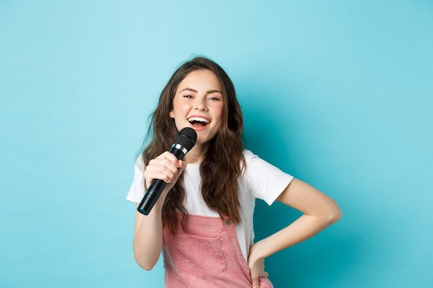 Mujer cantando karaoke con micrófono