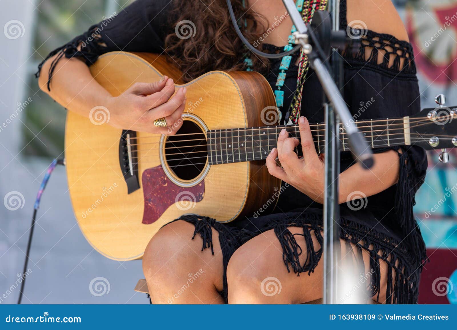 mujer tocando guitarra en un escenario